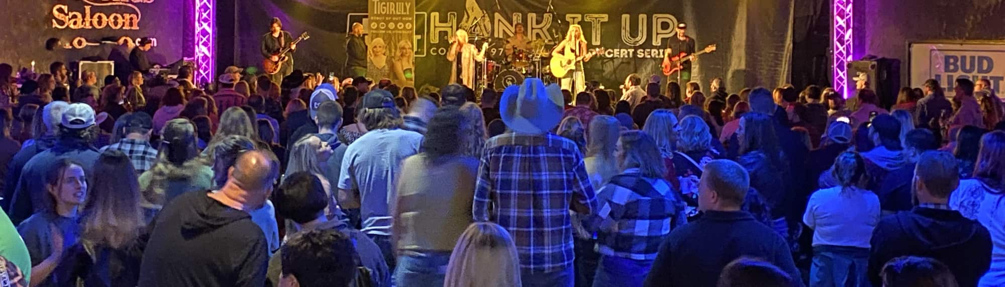 country concert with fans wearing cowboy hats Denver