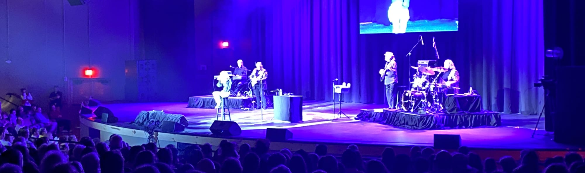 signer on stage in chair washed out by the lights Denver